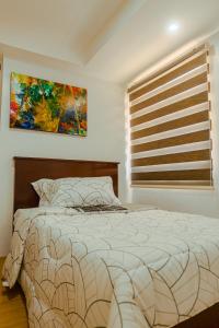 sypialnia z łóżkiem i oknem z obrazem w obiekcie Yong's Place at Isabelle de Valenzuela w mieście Manila