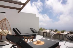 a patio with chairs and a hammock at Villa Nefeli Tinos in Triandáros