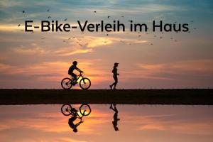 une personne faisant du vélo contre une personne sur un vélo au coucher du soleil dans l'établissement KRACHER Landhaus No. 2, à Illmitz