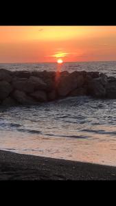un coucher de soleil sur l'océan avec un groupe de rochers dans l'établissement Casa Vacanza da LUCIA&PINA, à Piraino