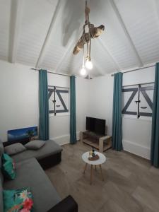 a living room with a couch and a tv at O'Parad'îles in Goyave