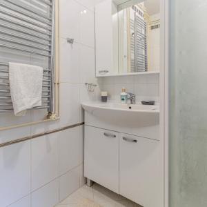 Un baño blanco con lavabo y espejo. en Vali Podolje, en Zagreb