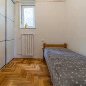 un dormitorio con una cama y una ventana en Vali Podolje, en Zagreb
