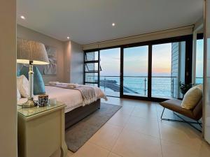a bedroom with a bed and a view of the ocean at Seafront Condo at The Pier 17 in Swakopmund