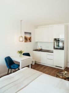 1 dormitorio blanco con escritorio y cocina en StrandBude, en Grömitz