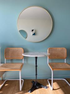 einen Tisch und zwei Stühle vor einem Spiegel in der Unterkunft La cabine de Léontine in La Baule