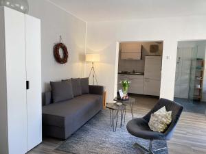a living room with a couch and a chair at WEINQUARTIER Naumburg 6 Apartments Eventraum Fahrradraum Kaffee Küche Parken in Naumburg