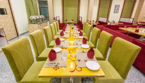 ein langes Esszimmer mit einem langen Tisch und Stühlen in der Unterkunft Hotel Yash Regency in Jaipur
