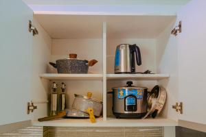 ein Küchenregal mit Töpfen und Pfannen darauf in der Unterkunft Yong's Place at Isabelle de Valenzuela in Manila