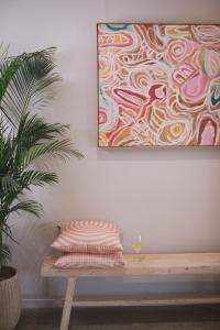une table avec un oreiller et une peinture murale dans l'établissement Emma's Cottage Vineyard, à Lovedale