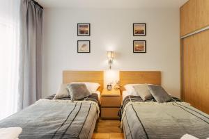 two beds sitting next to each other in a bedroom at Apartments Ustronie Morskie - RELAX in Ustronie Morskie +20 photos