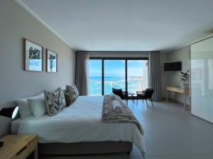 a bedroom with a bed with a view of the ocean at The Pier 29 in Swakopmund