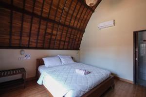 - une chambre avec un lit et une serviette dans l'établissement Loka Loka Ubud, à Gianyar