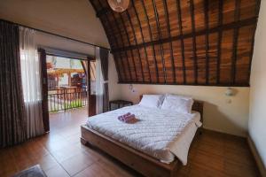- une chambre avec un lit et un balcon dans l'établissement Loka Loka Ubud, à Gianyar