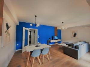 uma sala de estar com uma mesa e uma parede azul em N&A Apartment em Ohrid