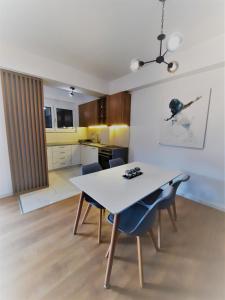 a kitchen and dining room with a white table and chairs at N&A Apartment in Ohrid