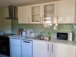 a kitchen with white cabinets and a sink and a microwave at Studio room in Oxford