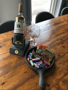 a bottle of wine and a plate of candy on a table at Casa 2234 op camping de Schatberg in Sevenum