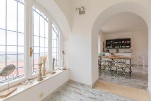 a living room with windows and a table with chairs at HelloElba Casa Rosa in Rio nellʼElba