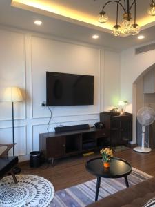 a living room with a flat screen tv on a wall at OASIS - FLC SEA TOWER in Quy Nhon +1 photo
