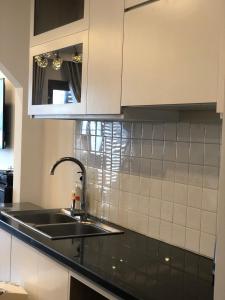 a kitchen counter with a sink and a mirror at OASIS - FLC SEA TOWER in Quy Nhon