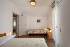 a white bedroom with a bed and a window at House Goga in Ledenice
