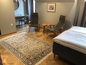 ボリホルムにあるGuntorps Herrgårdのベッドルーム(ベッド1台、椅子、テーブル付)