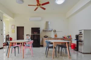 a kitchen with two tables and chairs and a ceiling fan at 欣京棧民宿 in Taitung City