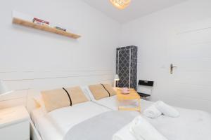 a white room with a bed and a table at Apartment Gdańsk Downtown by Renters in Gdańsk