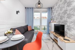 a living room with a couch and a table and a tv at Apartment Gdańsk Downtown by Renters in Gdańsk