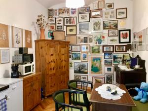 a kitchen with a table and chairs and a wall of pictures at KUNSTOASE FÜR ROMANTIKER in Rudersdorf