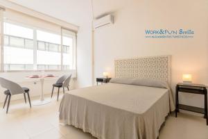 a bedroom with a bed and a table and chairs at Apartamento Martin Villa in Seville