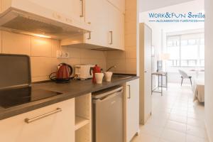 eine Küche mit weißen Schränken und einer Arbeitsplatte in der Unterkunft Apartamento Martin Villa in Sevilla