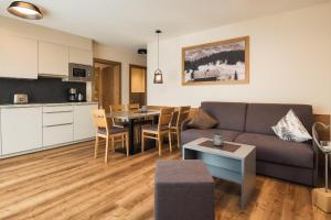 a living room with a couch and a table at Gabriela Appartements INKLUSIVE SUPER SOMMER CARD in Serfaus