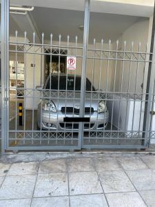 a car parked in a garage behind a gate at Ageliki's Athens Apartment in Athens
