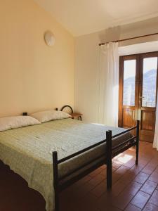 a bedroom with a bed and a large window at Rifugio La Mestà in Trassilico