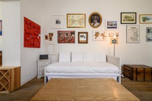 um quarto com duas camas e quadros na parede em Vespa Apartment em Nápoles