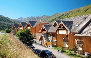 a row of houses with mountains in the background at Appartement 42M² pour 4/6 personnes à VALMEINIER 1800 in Valmeinier