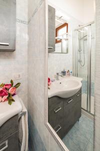 bagno con lavandino e specchio di APARTMENT L'ARCHETTO - Regarda Travel a Lazise