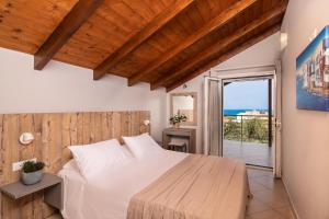 a bedroom with a bed and a view of the ocean at Armonia Boutique Hotel in Meson Yerakarion