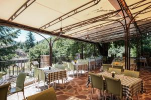 an outdoor dining area with tables and chairs at Hôtel Les Vignes in Chassiers