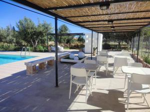 a patio with tables and chairs next to a swimming pool at Inkantu B&B in Terrasini