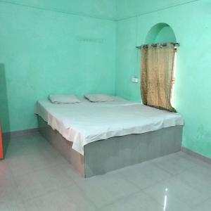 uma cama num quarto azul com uma janela em Shri Swami Sheetal Das Akhada B1-88 Assi , Near Pushkar Talab,Varanasi, Ashram Dharmshala em Varanasi