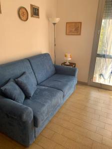 un sofá azul sentado en una sala de estar en mare e verde a celle ligure, en Celle Ligure