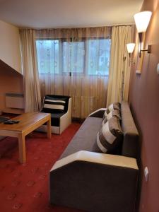 une chambre d'hôtel avec un canapé et une table dans l'établissement Complex Brashlyan, à Tryavna