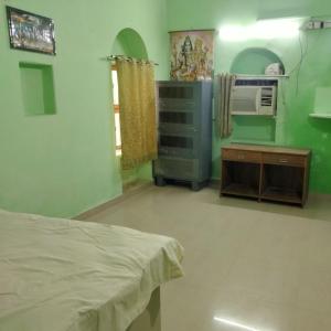 um quarto com uma cama, uma mesa e ar condicionado em Shri Swami Sheetal Das Akhada B1-88 Assi , Near Pushkar Talab,Varanasi, Ashram Dharmshala em Varanasi