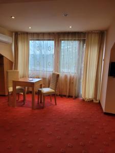 a room with a table and two chairs and a window at Complex Brashlyan in Tryavna