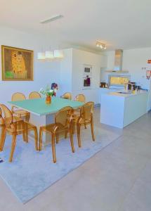 a dining room with a table and chairs and a kitchen at Villa Luz in Albufeira