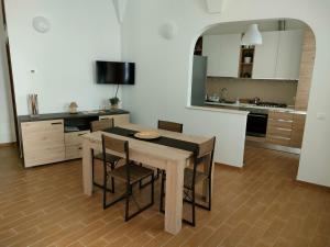 een keuken met een tafel en stoelen in een kamer bij Appartamento turistico I portici in LʼAquila