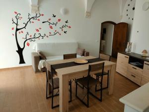 a kitchen with a table and a tree with birds on it at Appartamento turistico I portici in LʼAquila
